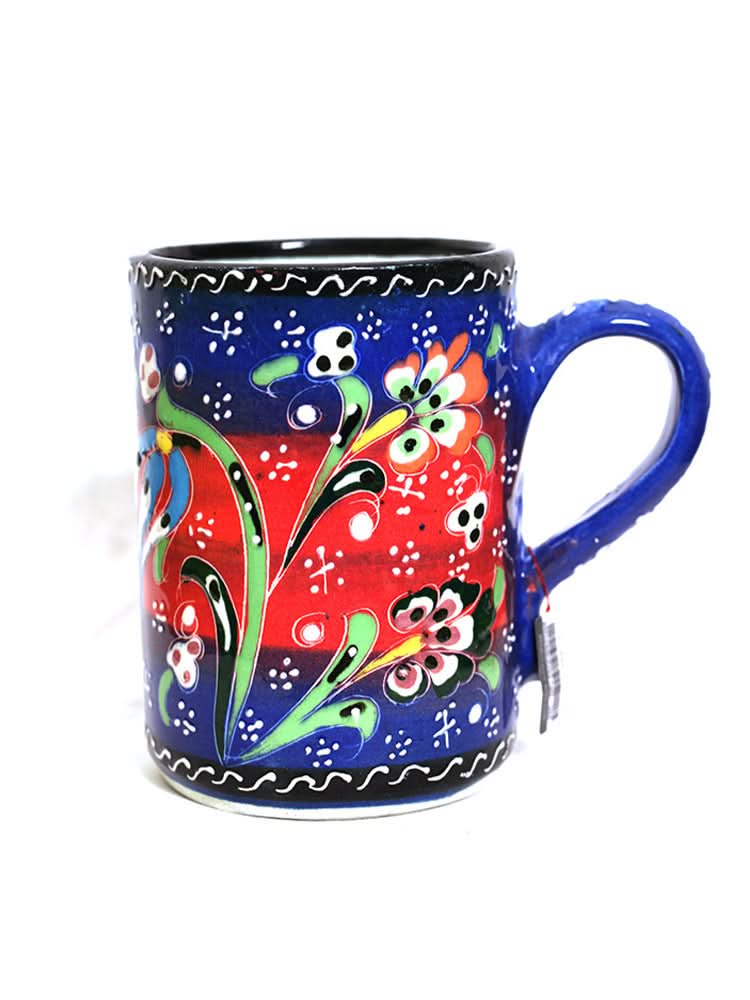 Vibrant Turkish glazed ceramic mug with floral patterns on blue and red background.